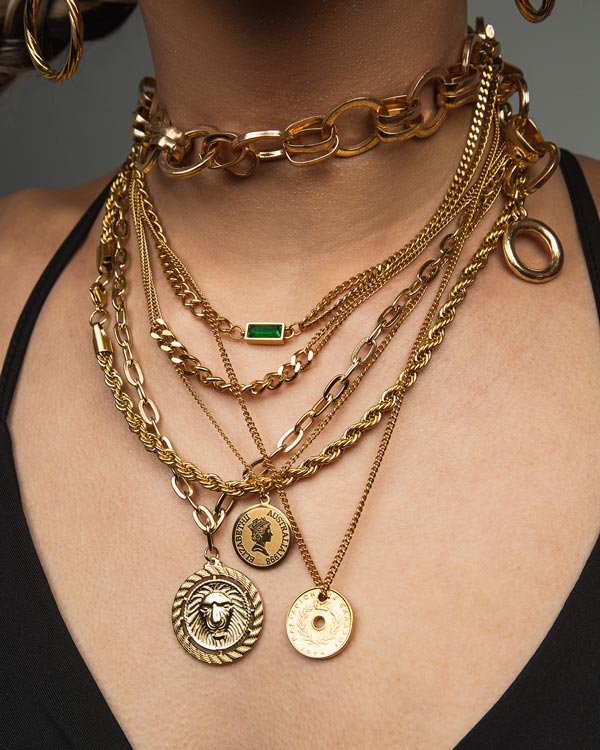 girl wears four stainless steel golden colour necklaces